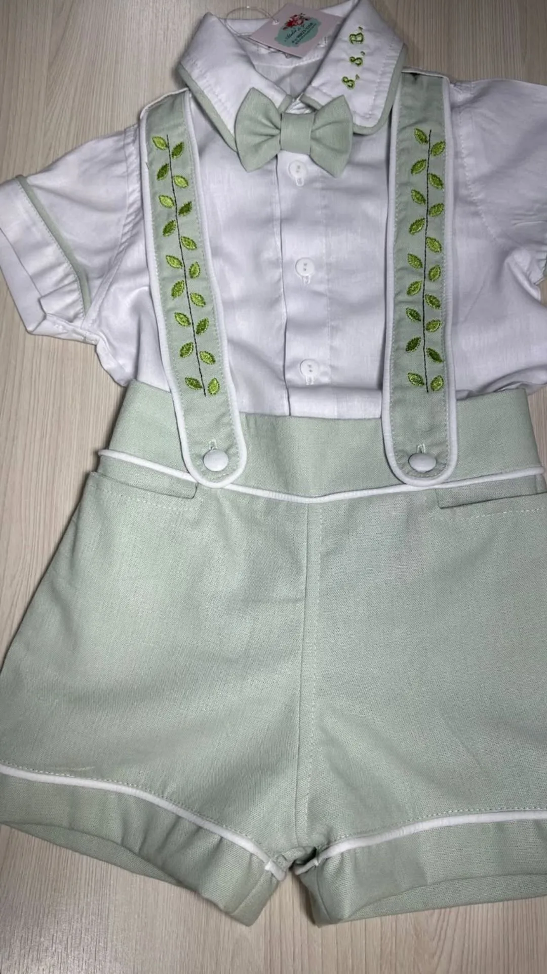 Conjunto Versátil infantil masculino — body com gola e botões, short coordenado e suspensório finalizando o look de ocasião especial