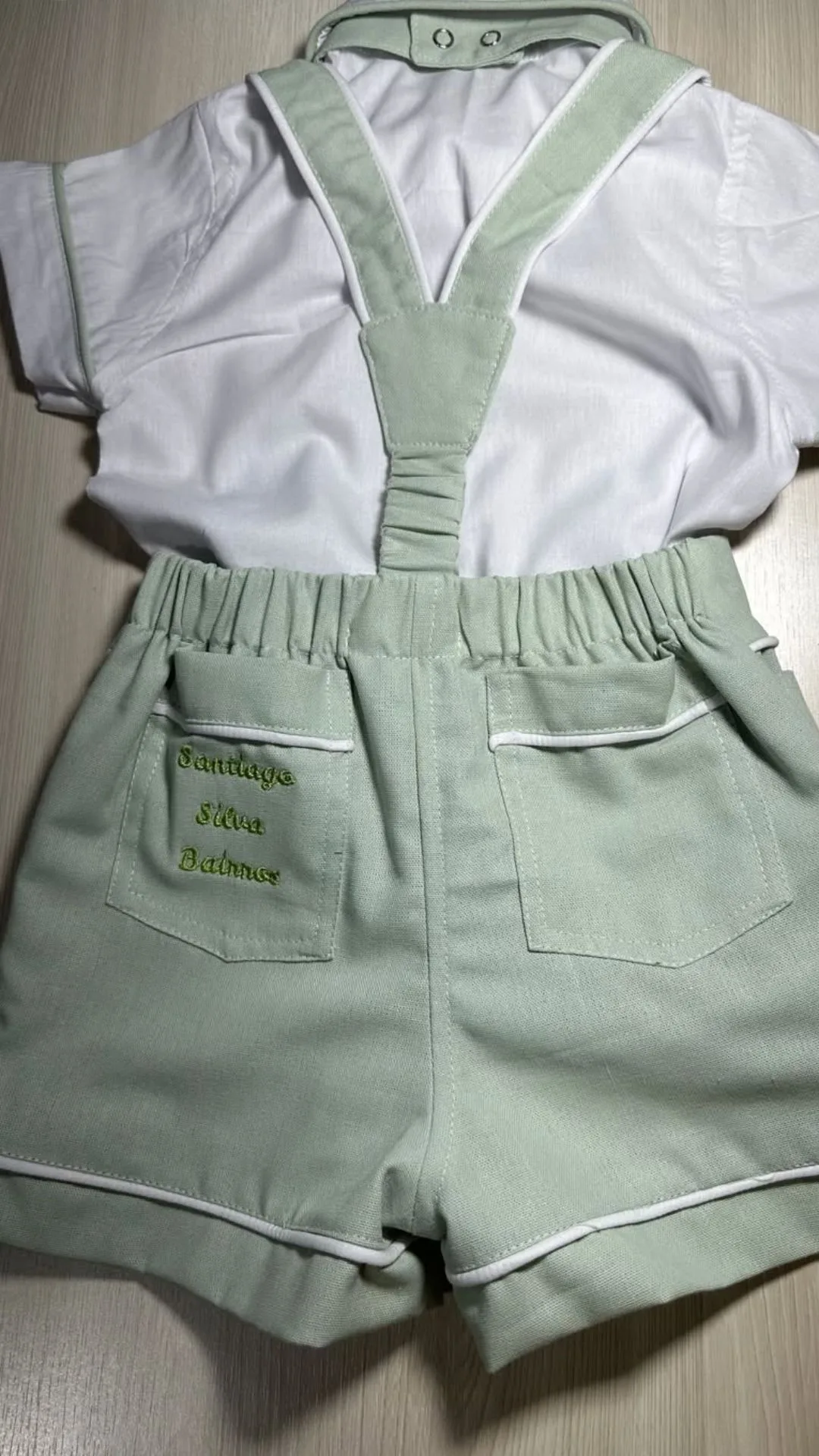 Conjunto Versátil visto pelas costas — body com acabamento do cós, suspensório cruzado e bermuda coordenada em tecido que dialoga com a camisa